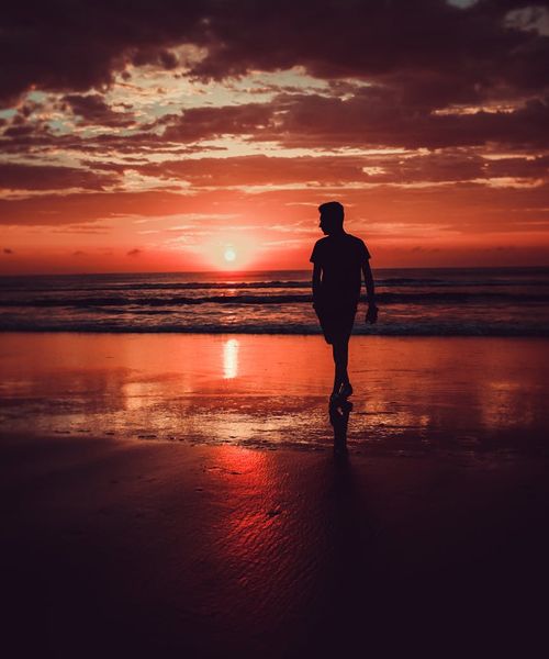 Silhouette of a person meditating in a serene environment.